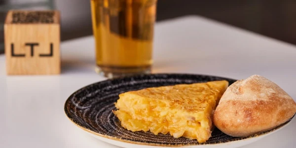 Pincho de tortilla de patatas con caña de cerveza en un local Lateral
