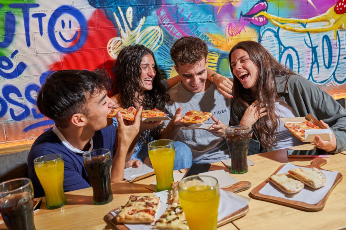Amigos disfrutando de la comida en Papizza