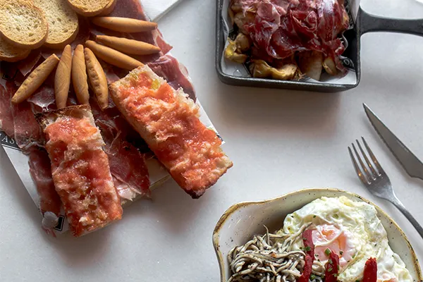 Mesa con platos de la carta de M&aacute;sQMenos