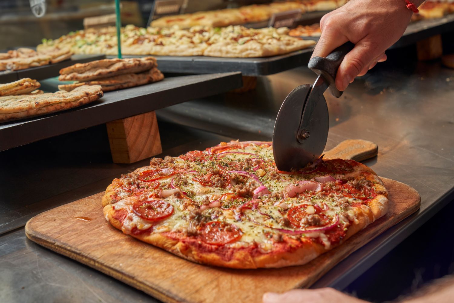 Mostrador con distintas pizzas en Papizza